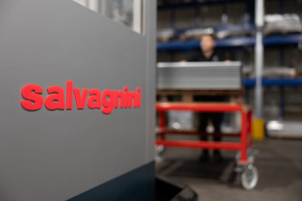Salvagnini branding on the side of the P2 lean automated panel bender at Unifabs Nuneaton with operative working in the background