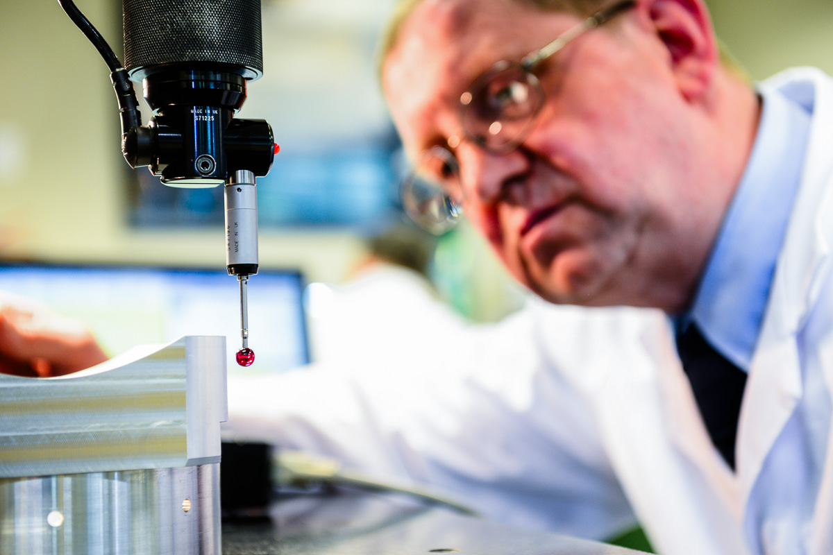 Photograph of technician using metrology equipment on metal manufactured engineering component