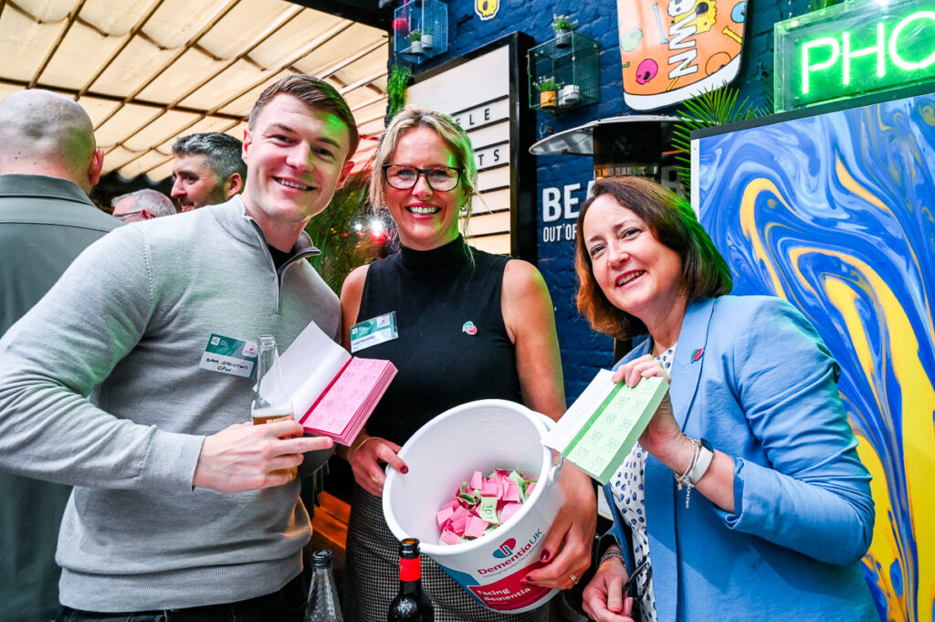 Photo - people showing off the bucket of raffle tickets at a charity event
