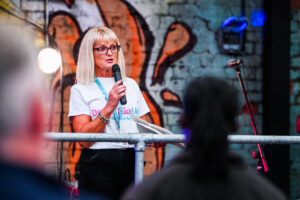 Lady with microphone speaking at a charity event